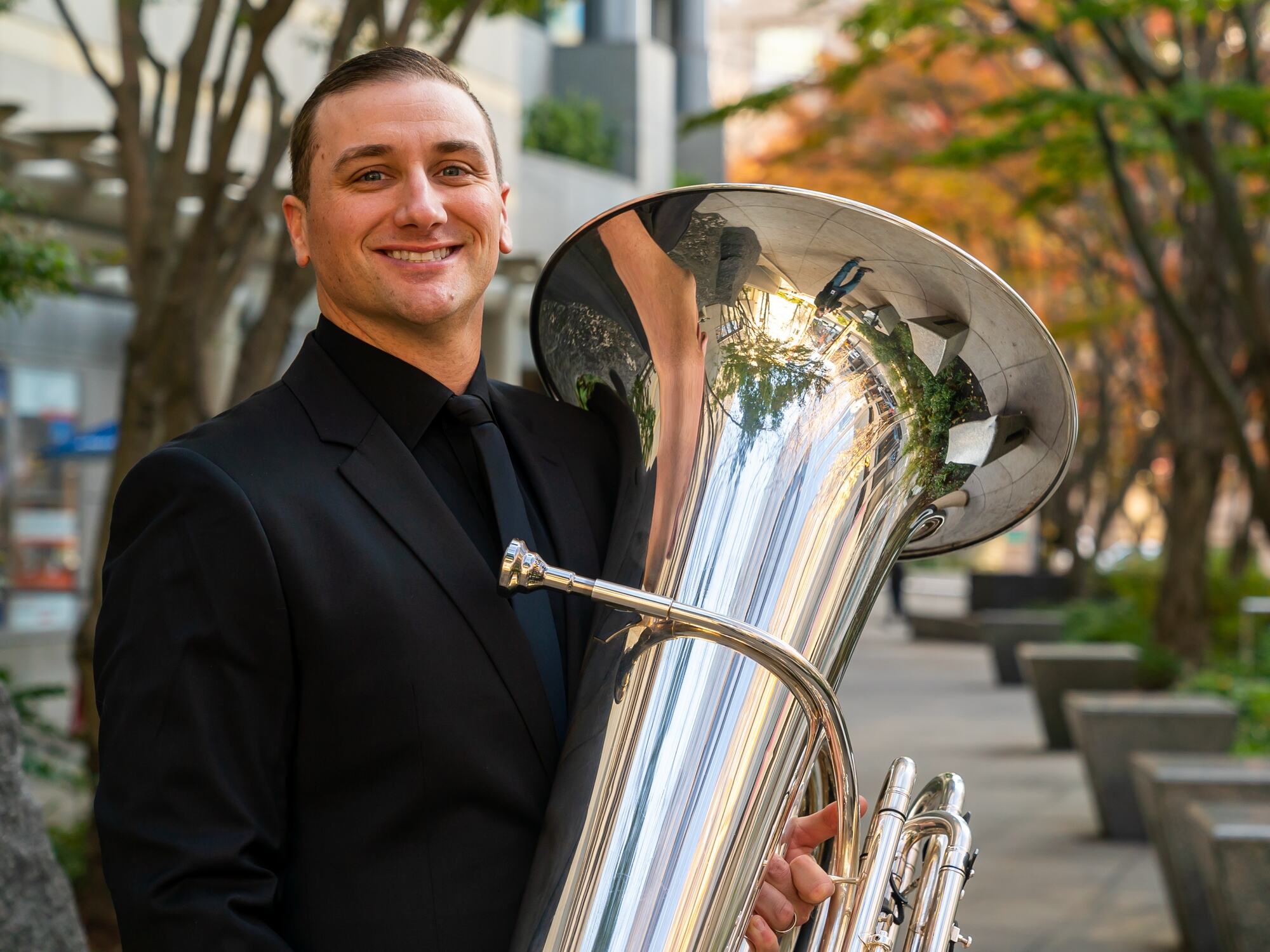 John DiCesare holding his tuba outdoors in Seattle